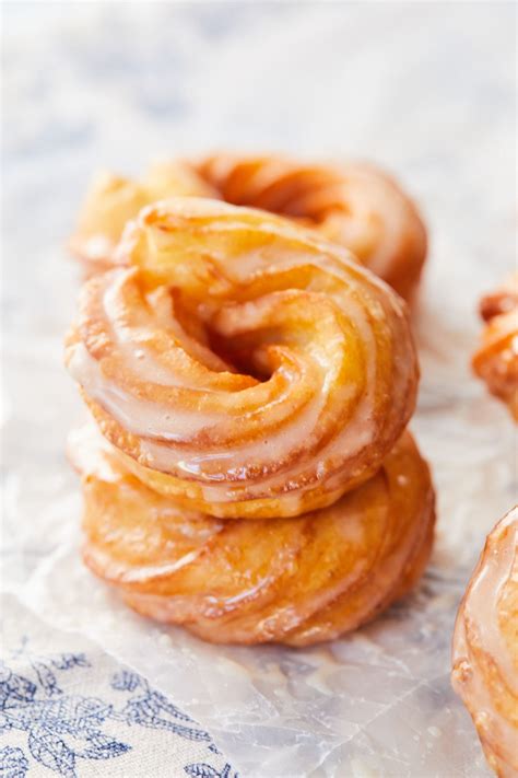 While the crullers cool, make the glaze. Place 1/4 cup honey, 2 tablespoons unsalted butter, and 1/2 teaspoon kosher salt in a medium microwave-safe bowl. Microwave in 30-second increments until the butter is melted, 30 seconds to 1 minute. Add 1 1/4 cups powdered sugar and whisk until smooth.